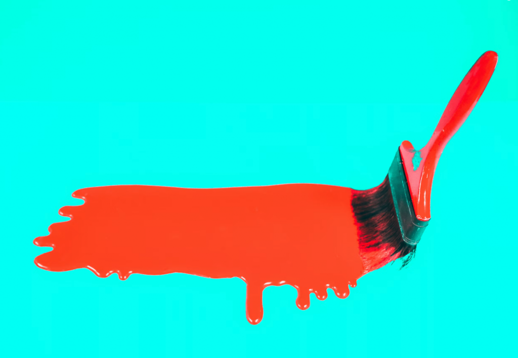 red paint brush with paint on it